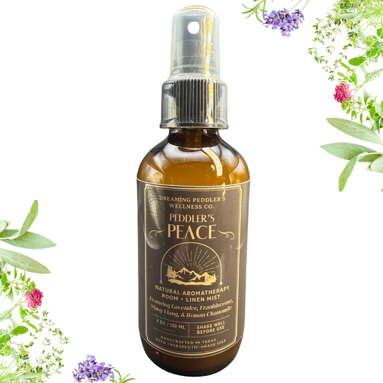 Bottle of Peddler's Peace natural aromatherapy spray with herbs in the background